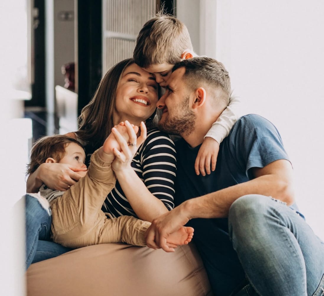 Young family with their sons at home having fun, smiling.