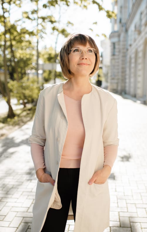 A closeup of a woman standing outside looking confidently up, past the camera and into the distance
