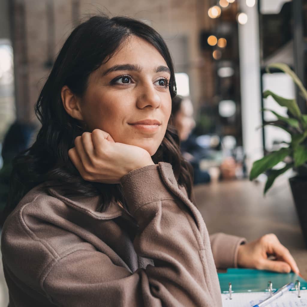 A woman looking off into the distance, in contemplation but with a hopeful gaze.